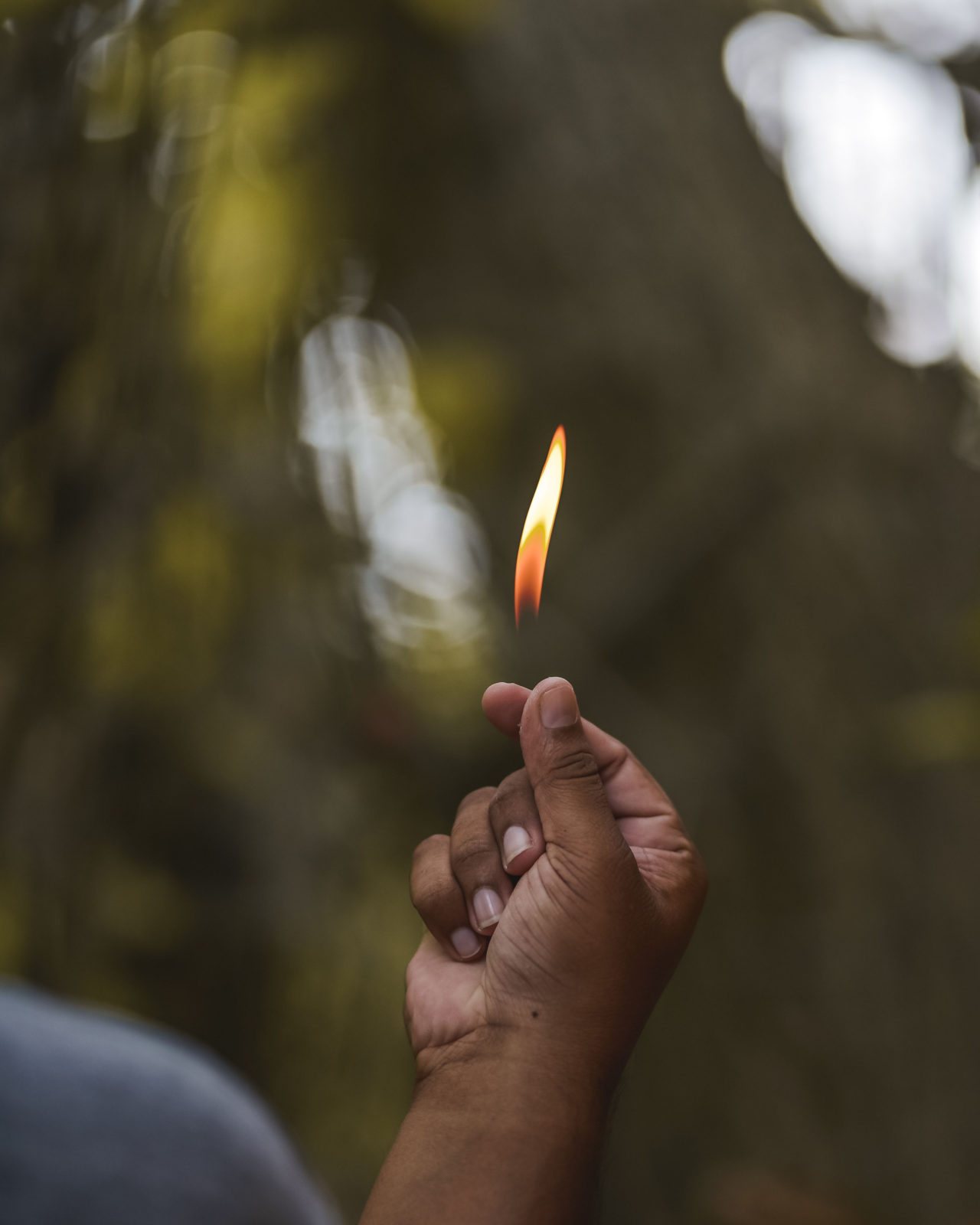 A person holding a lit match in their hand.